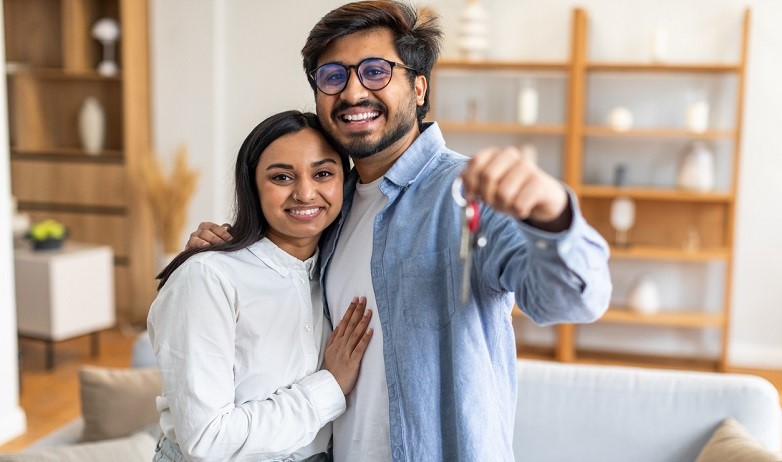happy young couple with keys have survived the property buying process